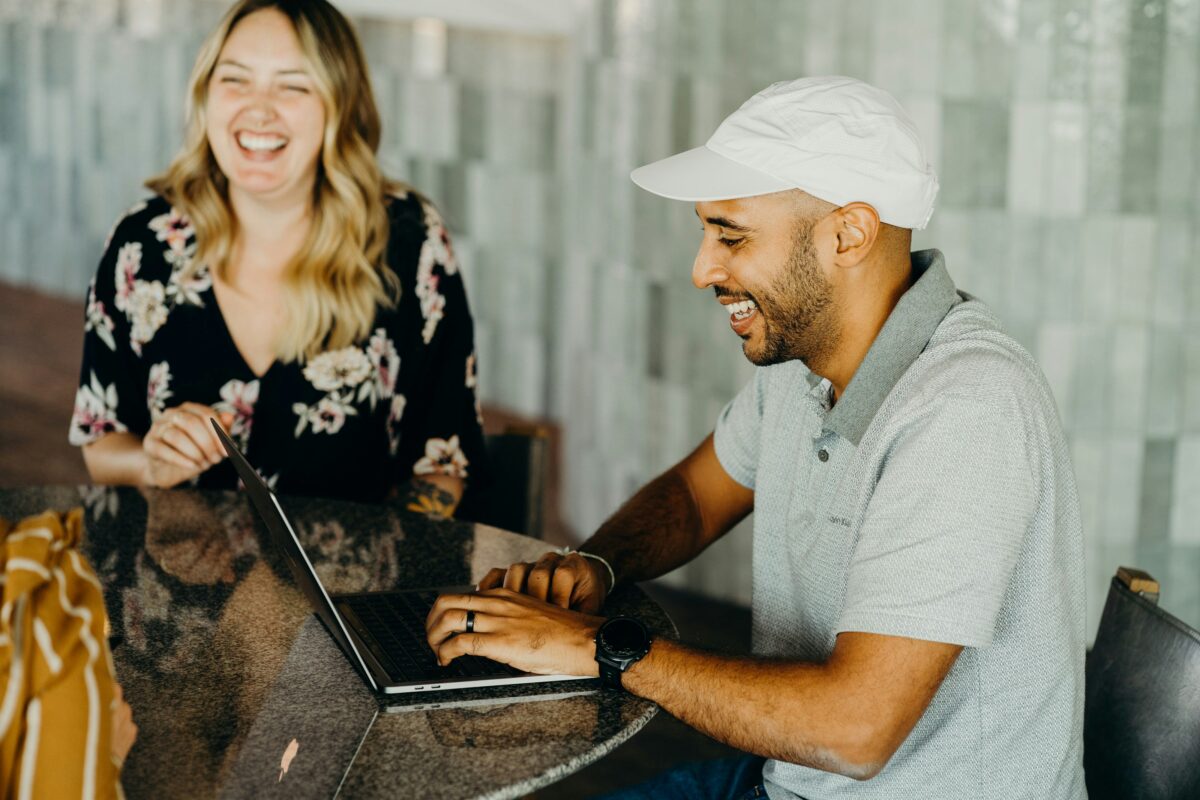 CRM program img. Guys and girl sitting in front of computer smiling